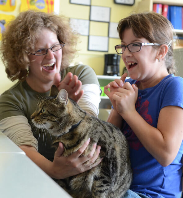 Kat in de klas met juf en meisje